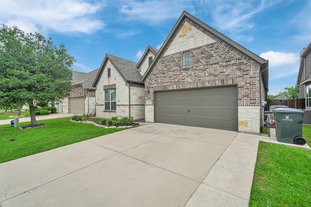 french country style house featuring stone siding, concrete driveway, and brick siding