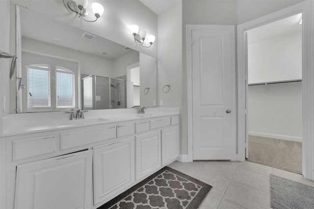 full bath featuring a shower stall, tile patterned floors, double vanity, baseboards, and a closet