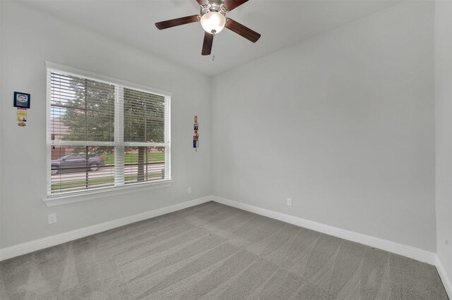 spare room featuring carpet flooring, baseboards, and ceiling fan