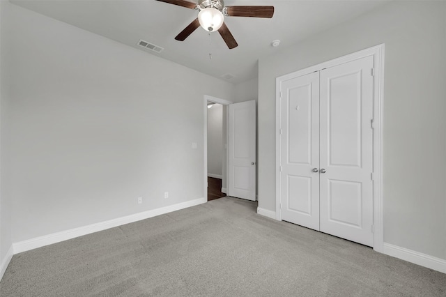 unfurnished bedroom featuring carpet, baseboards, a closet, and ceiling fan