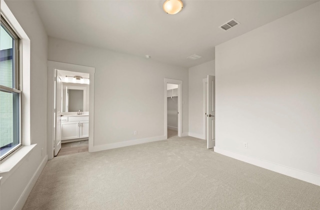 4732 Smokey Quartz Ln, Arlington, TX 76005 - unfurnished bedroom featuring light carpet, a walk in closet, multiple windows, and baseboards