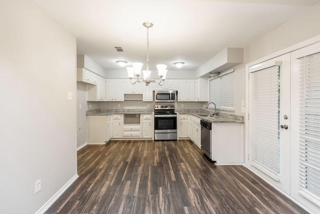 1017 Westminster Ln, Garland, TX 75040 - kitchen featuring appliances with stainless steel finishes, a sink, a chandelier, dark wood-style floors, and white cabinets