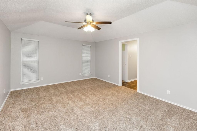 1017 Westminster Ln, Garland, TX 75040 - empty room with carpet, ceiling fan, baseboards, and vaulted ceiling