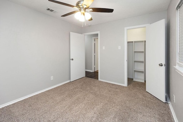 1017 Westminster Ln, Garland, TX 75040 - unfurnished bedroom featuring carpet floors, a walk in closet, a closet, baseboards, and ceiling fan