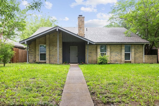 1017 Westminster Ln, Garland, TX 75040 - view of front facade with a chimney, brick siding, and roof with shingles