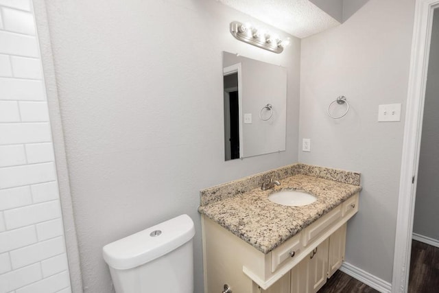 1017 Westminster Ln, Garland, TX 75040 - bathroom featuring wood finished floors, vanity, toilet, and baseboards