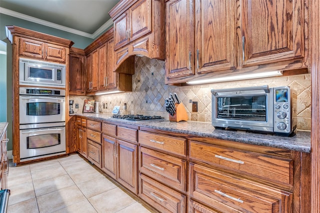 1615 San Andres Dr, Frisco, TX 75033 - kitchen with appliances with stainless steel finishes, brown cabinetry, ornamental molding, and backsplash