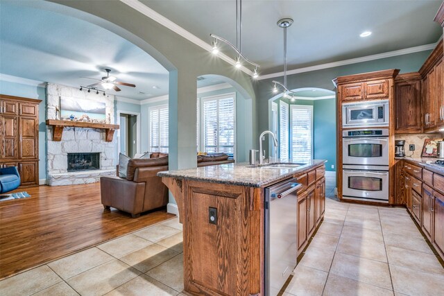 1615 San Andres Dr, Frisco, TX 75033 - kitchen featuring a sink, appliances with stainless steel finishes, ceiling fan, crown molding, and light stone countertops