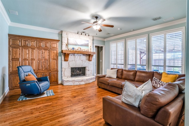1615 San Andres Dr, Frisco, TX 75033 - living area featuring ceiling fan, light wood-type flooring, a stone fireplace, ornamental molding, and baseboards