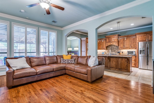 1615 San Andres Dr, Frisco, TX 75033 - living area featuring ceiling fan, arched walkways, crown molding, and light wood finished floors