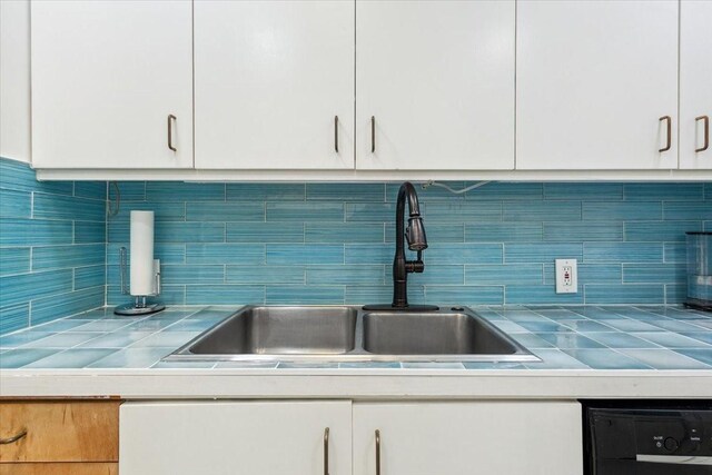 3020 N 43rd St, Waco, TX 76710 - kitchen with a sink, white cabinets, dishwasher, tile countertops, and backsplash