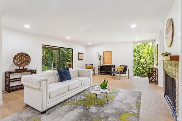 3020 N 43rd St, Waco, TX 76710 - living room featuring a tiled fireplace, light wood-type flooring, and recessed lighting