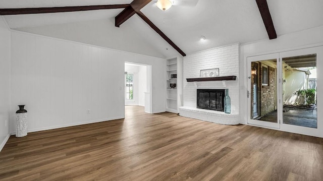 unfurnished living room with wood finished floors, a fireplace, built in shelves, and baseboards