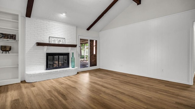 unfurnished living room with wood finished floors, a brick fireplace, and built in features