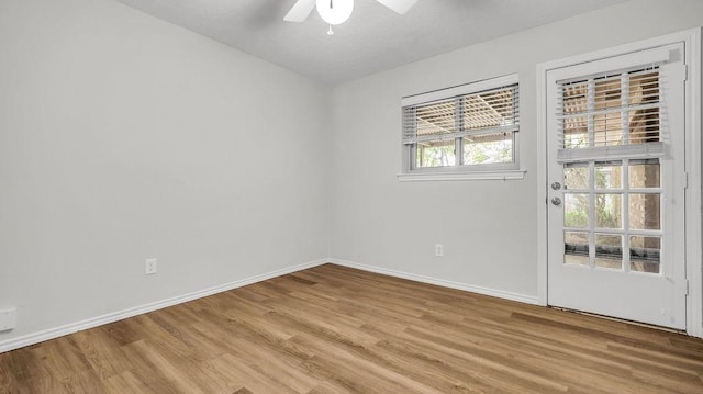 unfurnished room featuring a ceiling fan, light wood-style floors, and baseboards