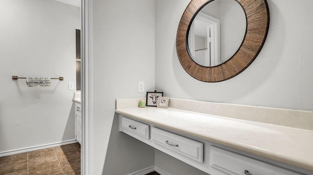 bathroom featuring vanity, baseboards, and stone finish flooring