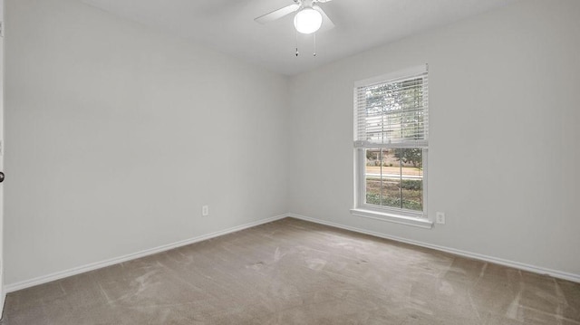 unfurnished room featuring a ceiling fan, carpet flooring, and baseboards