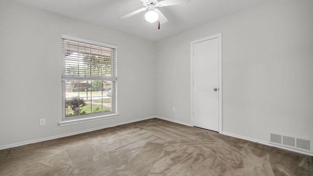 carpeted empty room featuring baseboards and ceiling fan