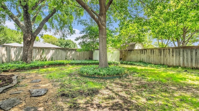fenced backyard with a shed and an outbuilding