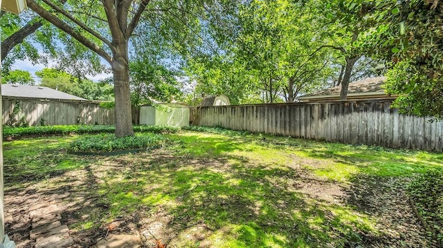fenced backyard with a storage unit and an outdoor structure