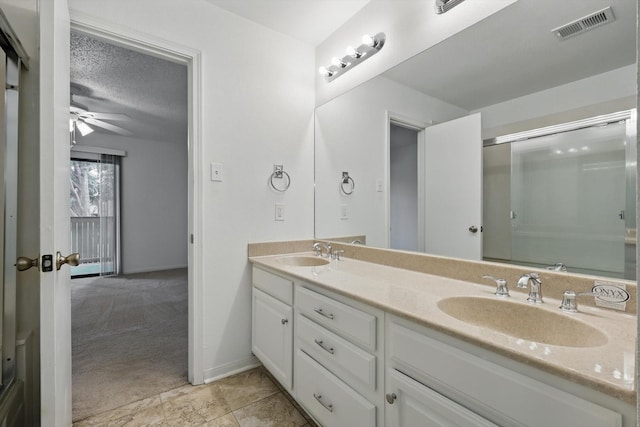 2000 Willoughby Ln Unit 5520, Arlington, TX 76011 - bathroom featuring double vanity, an enclosed shower, ceiling fan, and a textured ceiling
