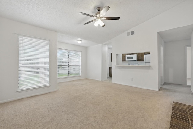 2000 Willoughby Ln Unit 5520, Arlington, TX 76011 - unfurnished living room with light carpet, ceiling fan, baseboards, vaulted ceiling, and a textured ceiling