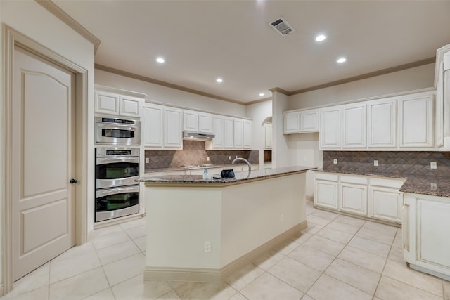 2137 Langdon Dr, Frisco, TX 75033 - kitchen featuring under cabinet range hood, ornamental molding, backsplash, dark stone countertops, and recessed lighting