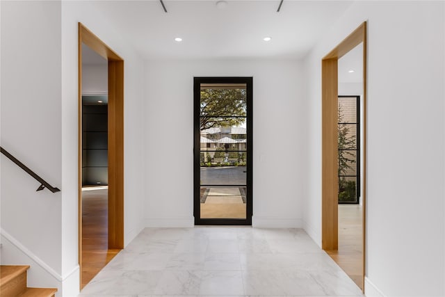 entryway featuring baseboards, light marble finish floors, recessed lighting, and stairway