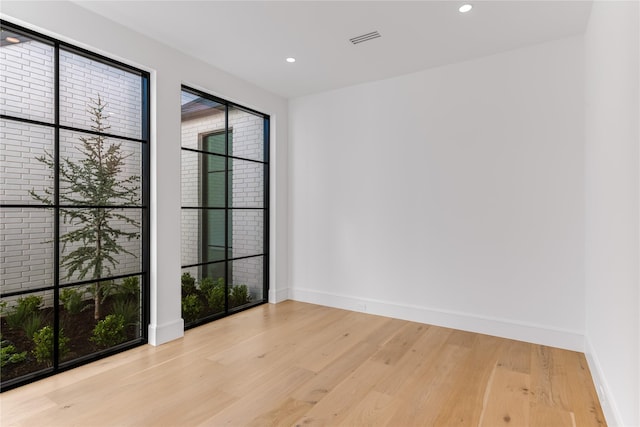unfurnished room featuring wood finished floors, baseboards, and recessed lighting