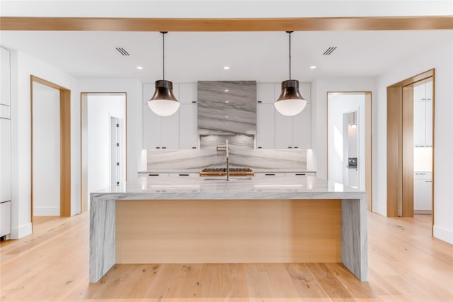 kitchen featuring modern cabinets, white cabinets, a large island, baseboards, and recessed lighting