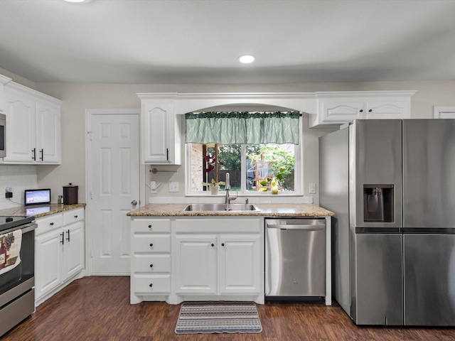 kitchen featuring stainless steel appliances, a sink, dark wood finished floors, white cabinets, and recessed lighting