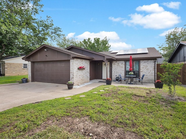 624 Hallvale Dr, White Settlement, TX 76108 - view of front of house featuring a garage, roof mounted solar panels, brick siding, and driveway