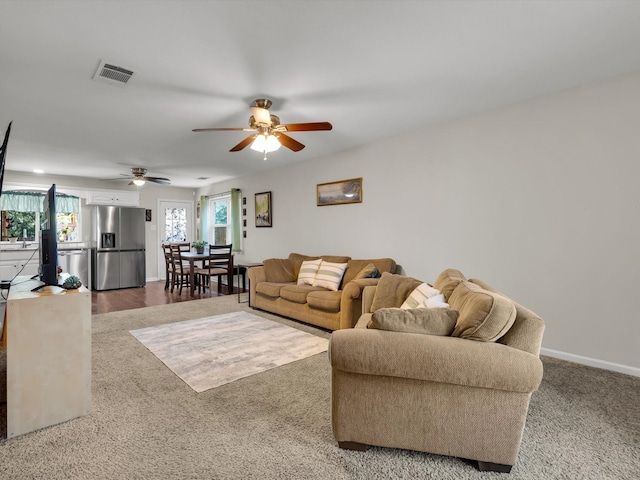 living area featuring a ceiling fan, carpet flooring, and baseboards