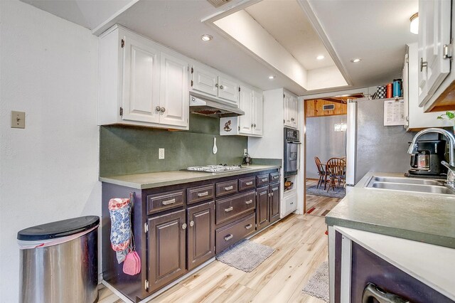814 Branding Iron Trl, Granbury, TX 76049 - kitchen with oven, a sink, under cabinet range hood, white cabinetry, and light wood-type flooring