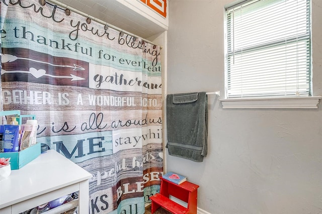 814 Branding Iron Trl, Granbury, TX 76049 - bathroom featuring plenty of natural light, a shower with shower curtain, and baseboards