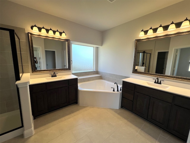 bathroom featuring tile patterned floors, two vanities, a shower stall, and a garden tub