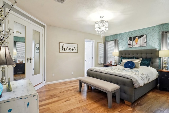 1010 Kings Canyon Ct, Grapevine, TX 76051 - bedroom with a chandelier, light wood-style flooring, baseboards, and wallpapered walls