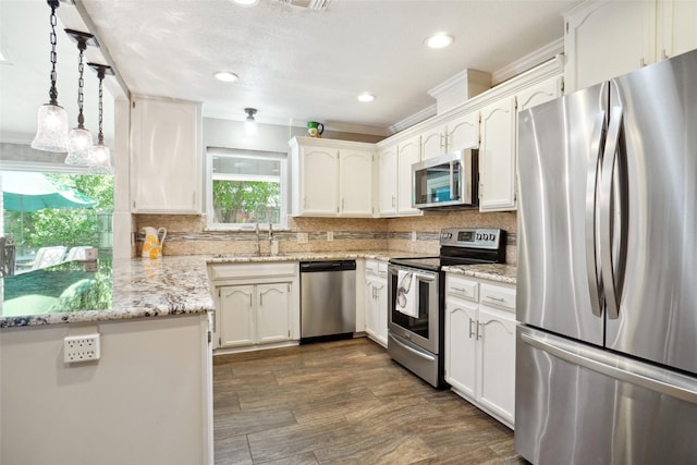 1010 Kings Canyon Ct, Grapevine, TX 76051 - kitchen featuring appliances with stainless steel finishes, a sink, white cabinetry, recessed lighting, and ornamental molding