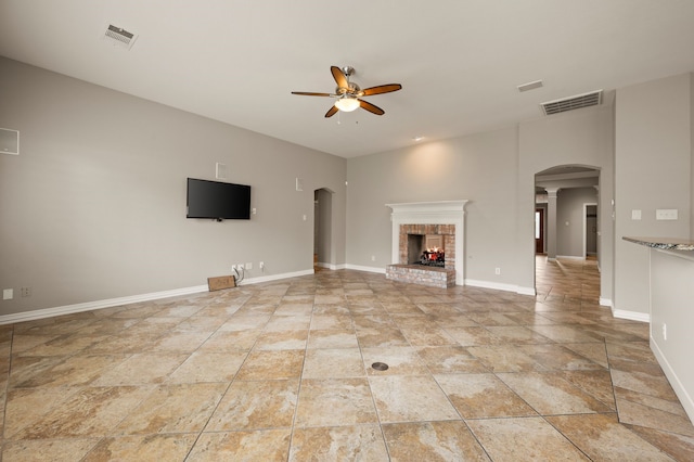904 Blue Jay Ln, Coppell, TX 75019 - unfurnished living room with a ceiling fan, arched walkways, a fireplace, and baseboards