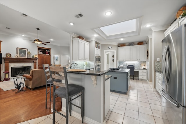 4019 Brooks Ct, Highland Village, TX 76226 - kitchen with stainless steel appliances, crown molding, a peninsula, light tile patterned flooring, and tasteful backsplash