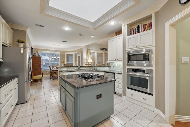 4019 Brooks Ct, Highland Village, TX 76226 - kitchen featuring stainless steel appliances, ornamental molding, a peninsula, a raised ceiling, and decorative backsplash