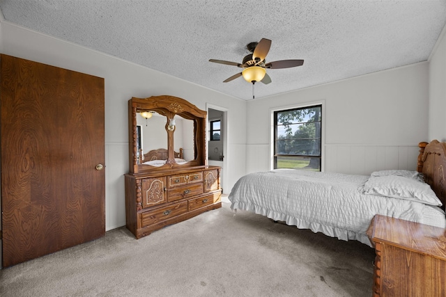 150 N Powell Dr, Hubbard, TX 76648 - bedroom featuring a textured ceiling, carpet floors, wainscoting, and ceiling fan