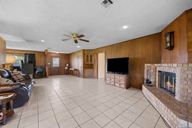 150 N Powell Dr, Hubbard, TX 76648 - living area with wooden walls, ceiling fan, a brick fireplace, a textured ceiling, and light tile patterned floors