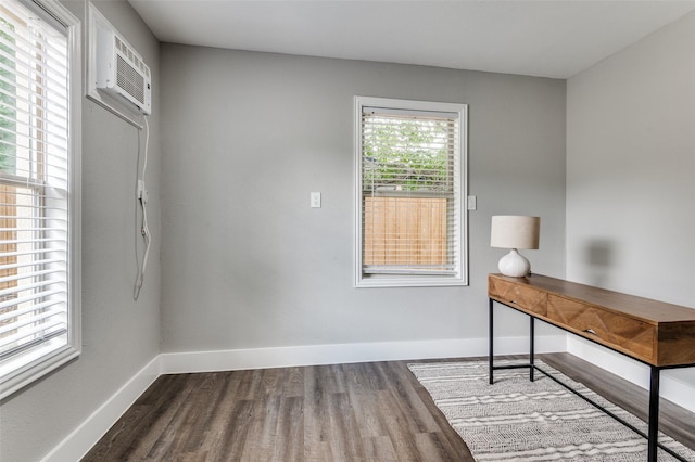 437 22nd St, Grand Prairie, TX 75050 - unfurnished office with dark wood-style flooring, baseboards, and an AC wall unit