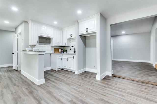 437 22nd St, Grand Prairie, TX 75050 - kitchen with decorative backsplash, white cabinets, light wood-style flooring, baseboards, and recessed lighting