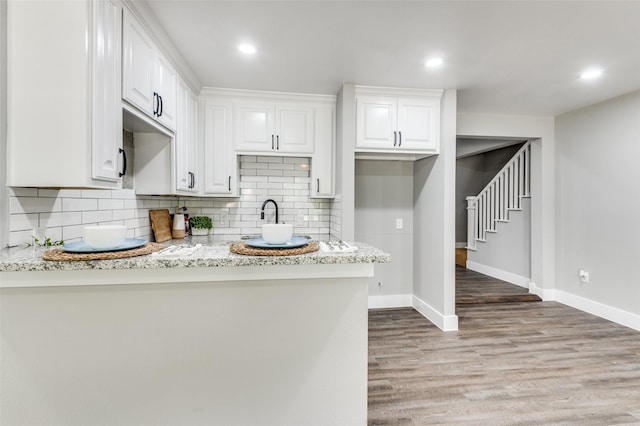 437 22nd St, Grand Prairie, TX 75050 - kitchen with white cabinets, tasteful backsplash, light wood-type flooring, baseboards, and recessed lighting