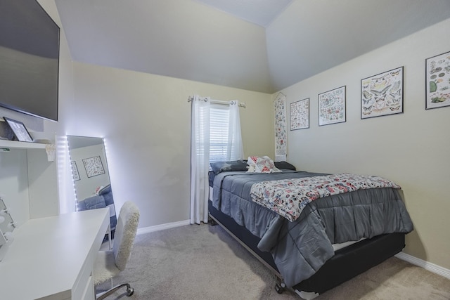 carpeted bedroom with lofted ceiling and baseboards