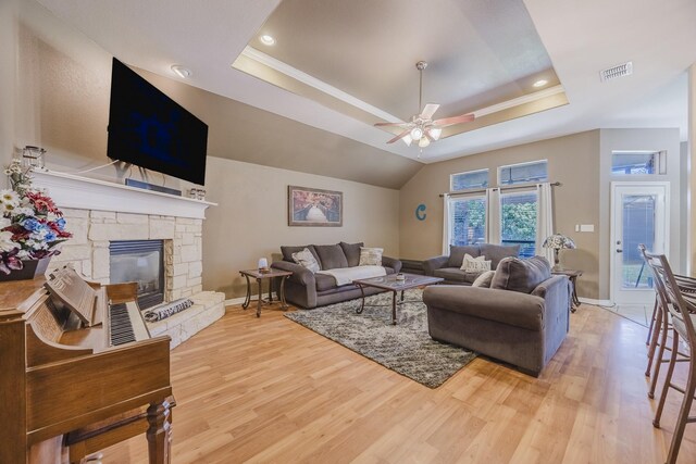 living room with baseboards, a tray ceiling, light wood finished floors, ceiling fan, and recessed lighting