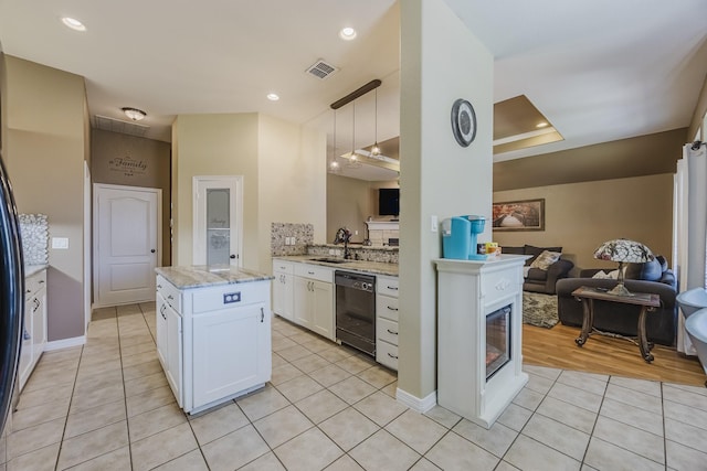 kitchen featuring black dishwasher, open floor plan, light tile patterned floors, white cabinets, and a sink