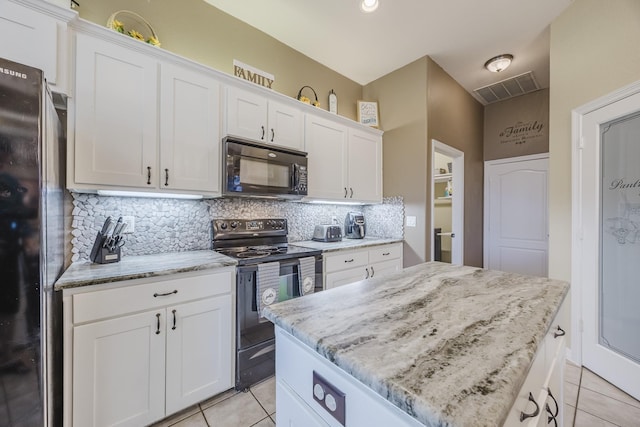 kitchen with black appliances, light tile patterned floors, a center island, backsplash, and white cabinets